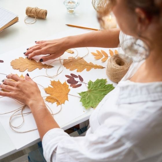 woman crafting with leaves and string Opens in new window